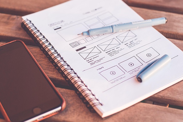 a cell phone and notebook with mockup of a website on page